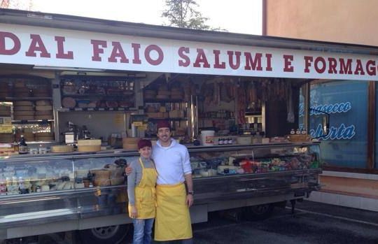 Alessandro Farina davanti al banco di salumi e formaggi, con la moglie Elena